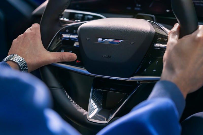 Close-up of a Man About to Press the V-Button on the 2026 OPTIQ-V Steering Wheel | Wackerli Cadillac of Idaho Falls in Idaho falls ID