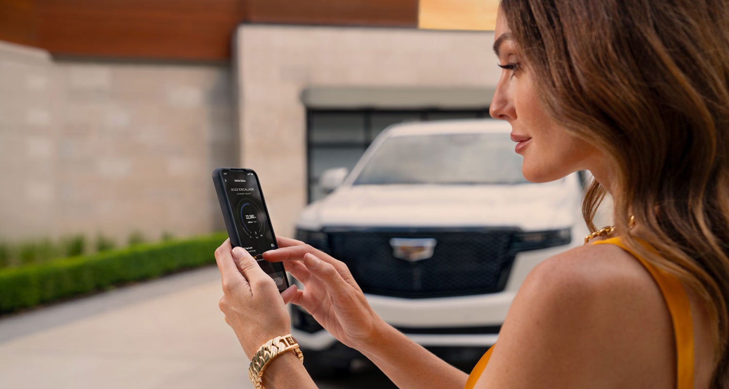 lady checking her mobile with a Cadillac vehicle background | Wackerli Cadillac of Idaho Falls in Idaho falls ID